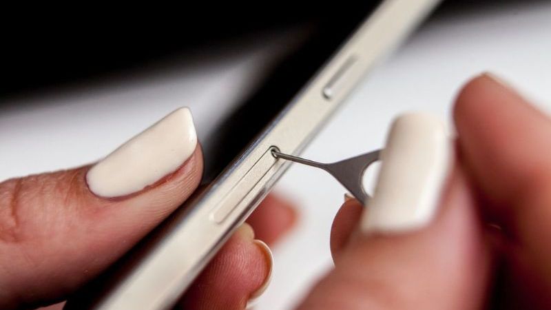 Sử dụng que chọc SIM để mở khay SIM